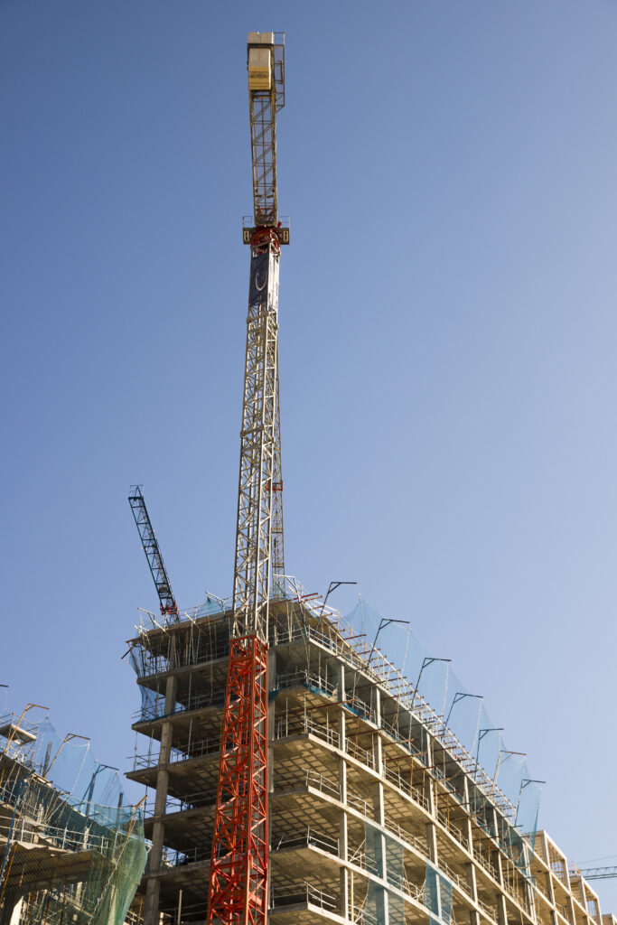 low angle view construction crane near site against blue sky